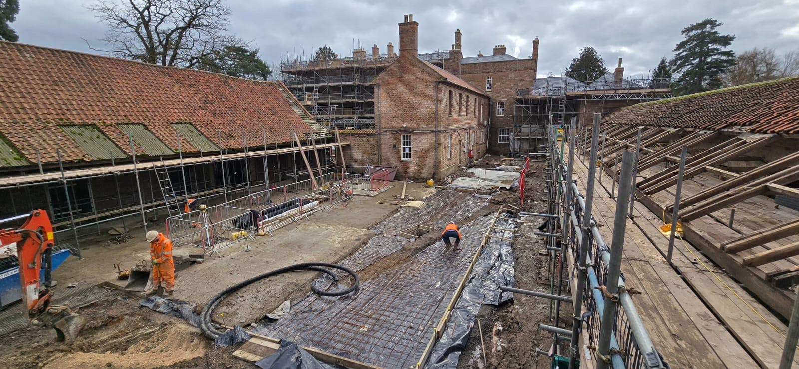 Mesh reinforcement laid over DPM ready for pour in the stable courtyard at South Ormsby Estate, with the Georgian brick hall behind