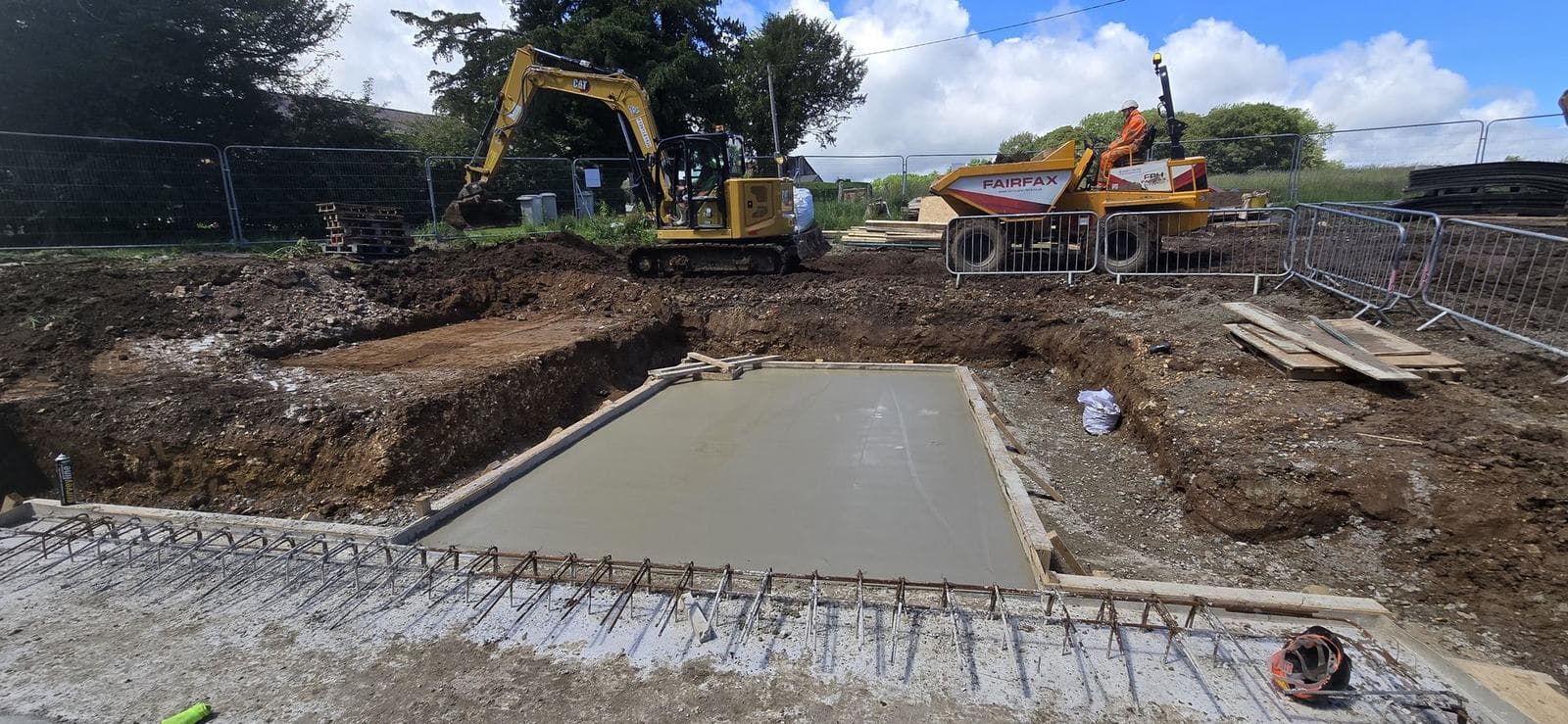 Freshly cast reinforced concrete slab sitting in a shallow reduced-level dig