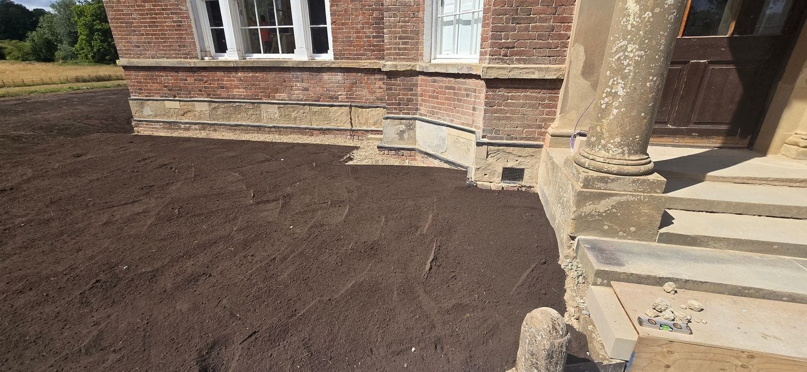 Reduced-level regrade around the base of the Georgian red brick hall