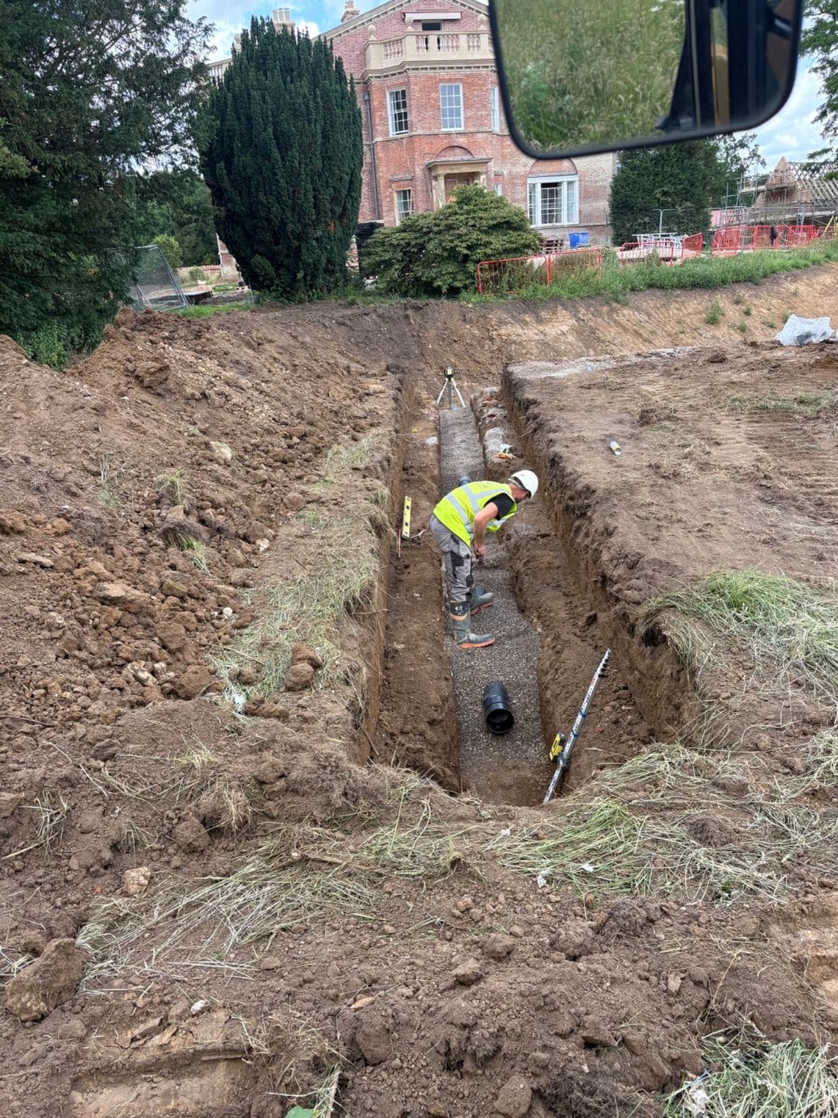 Deep benched excavation with a narrow pipe trench cut into the formation
