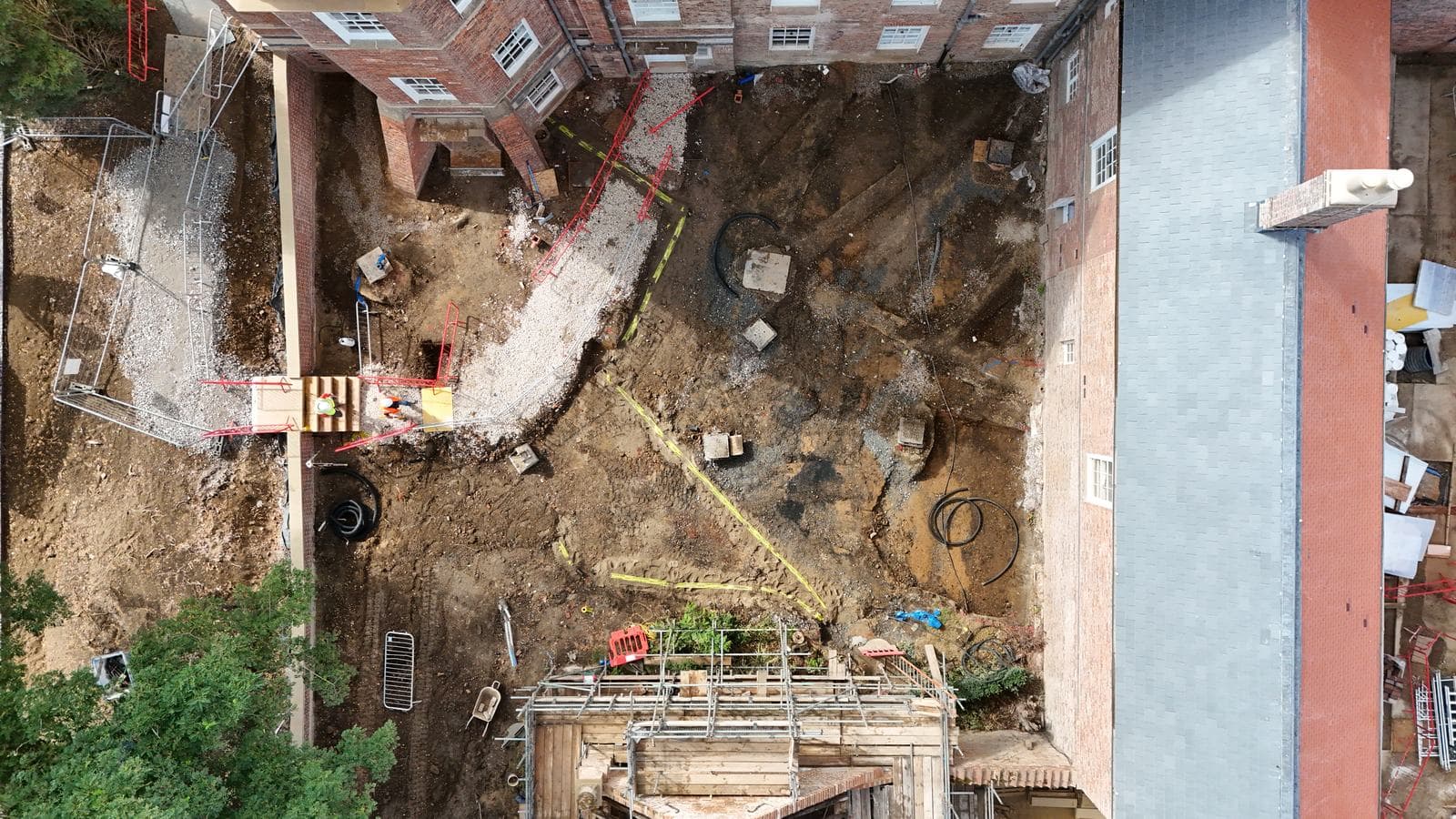 Drone view looking straight down on courtyard groundworks within the heritage buildings