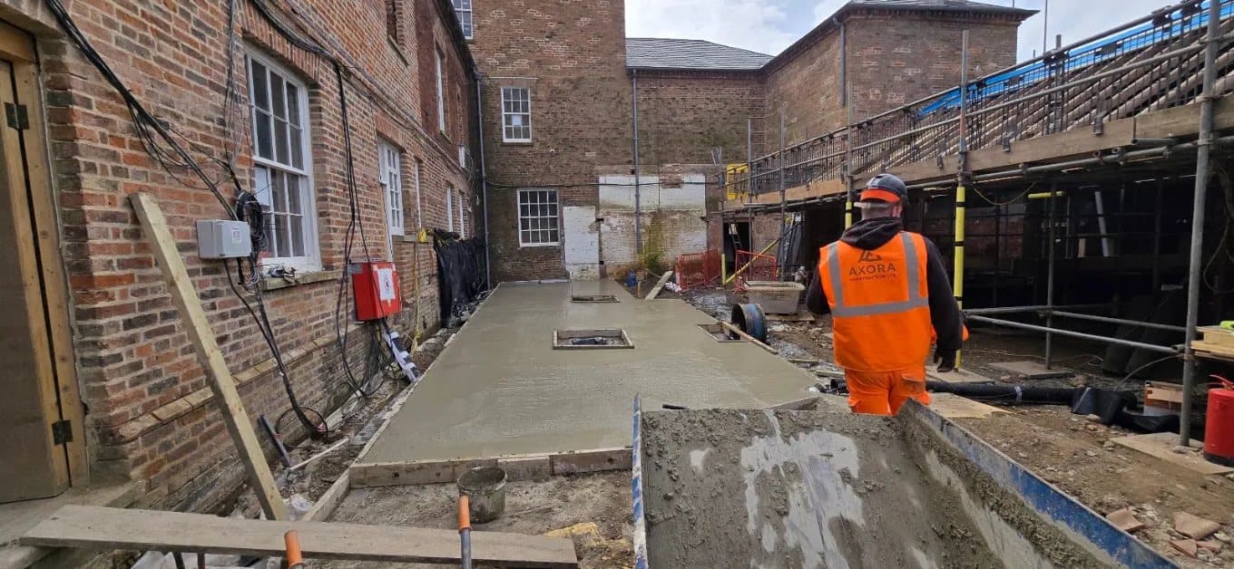 Finished concrete slab in the courtyard with an operative working on