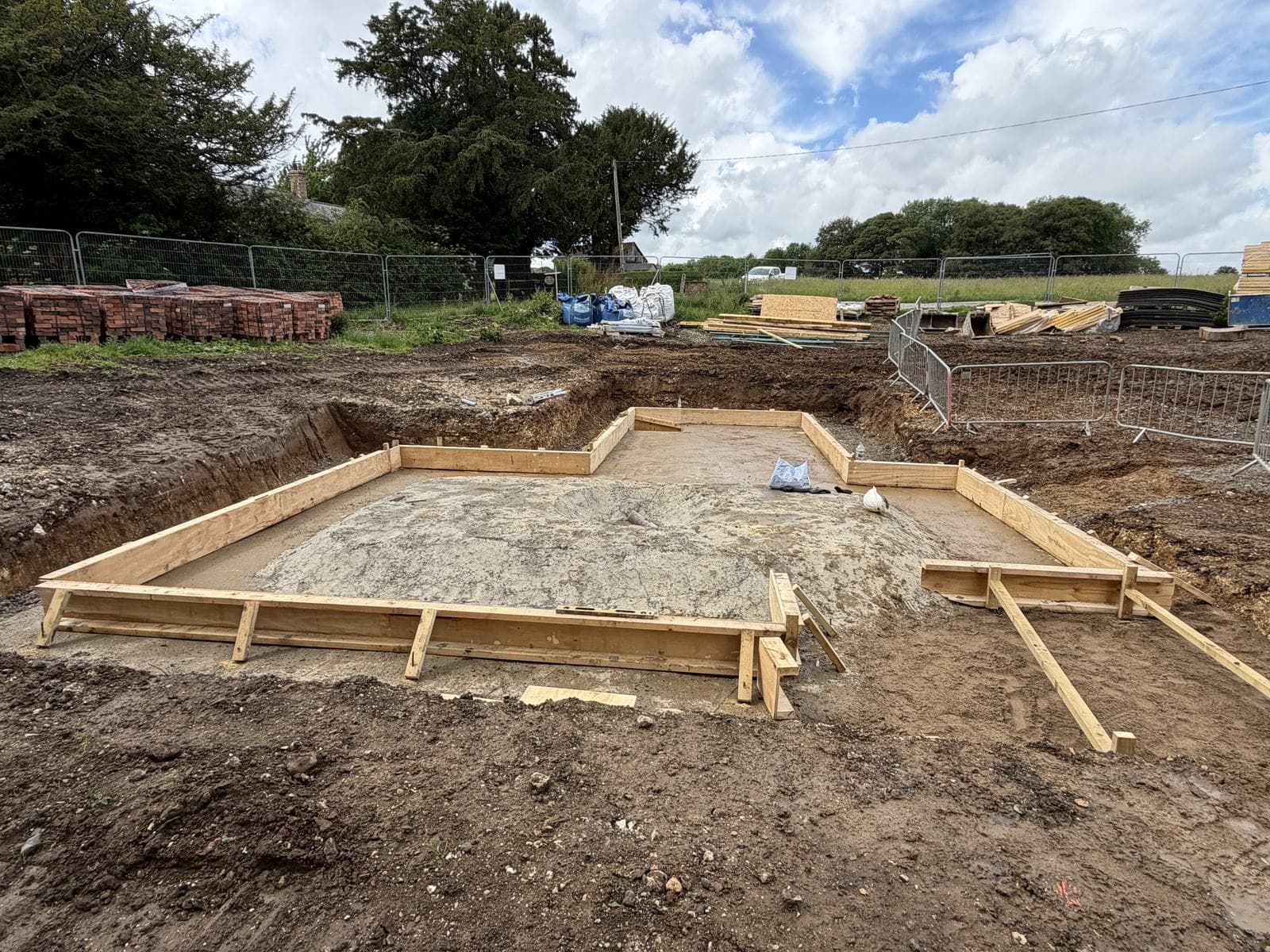 Timber edge formwork set out around a prepared slab base in the parkland