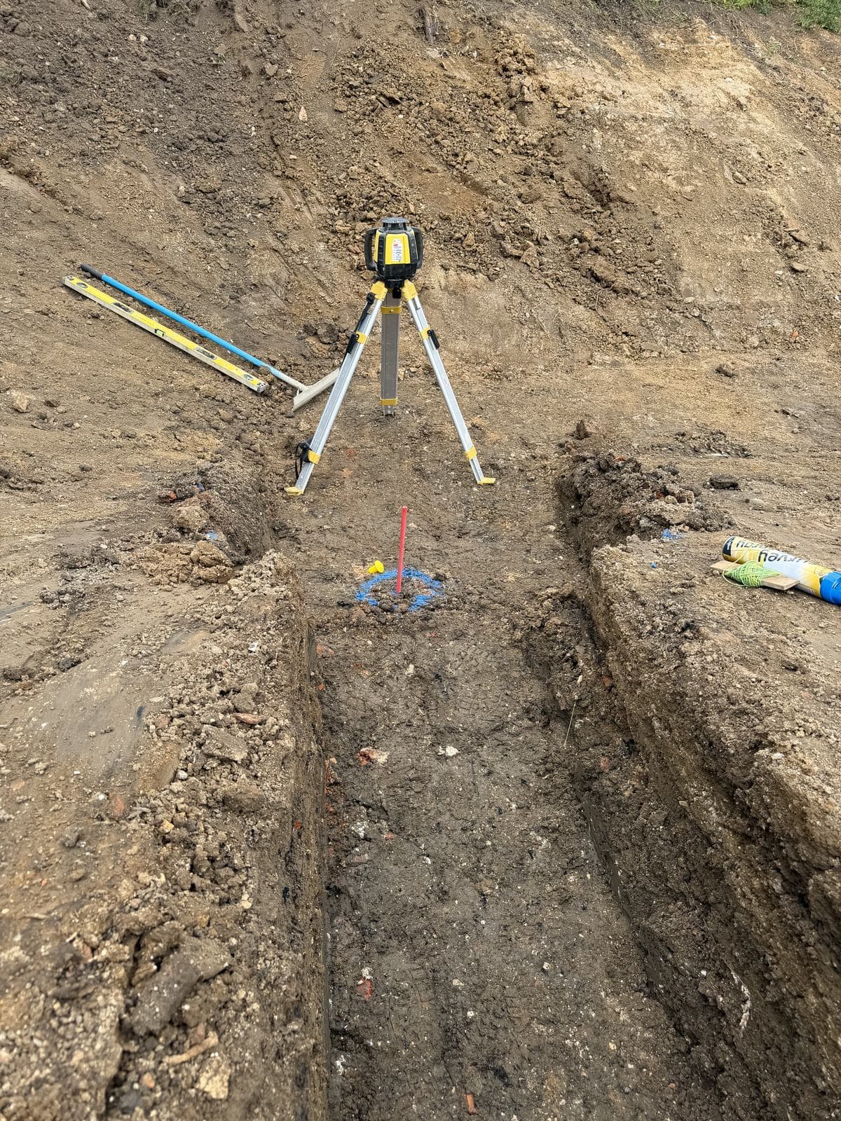 Laser level set over a trench for setting out to level
